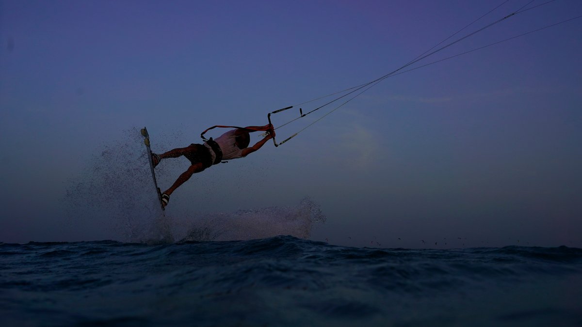 man kitesurfing in sea unhooking
